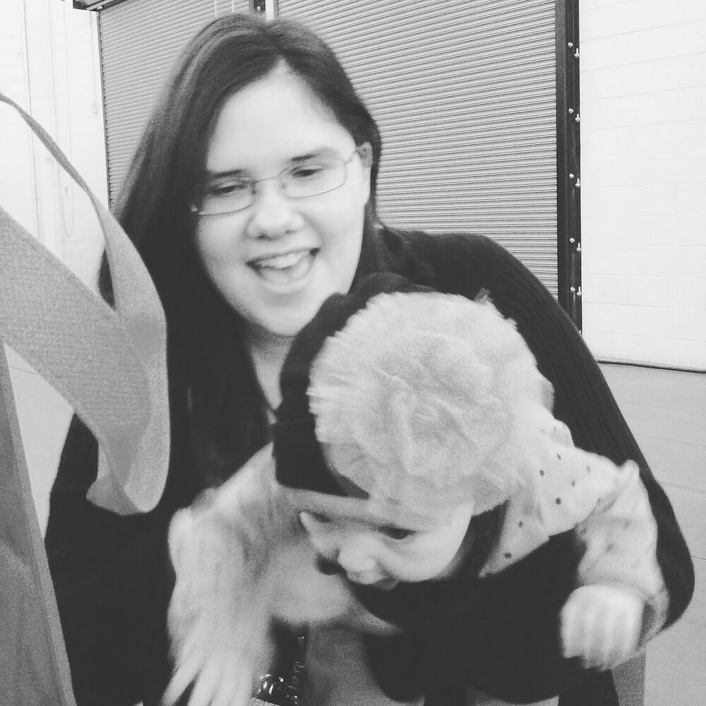Black-and-white photo of my baby cousin Solara and I, with her leaning forward and me laughing mid-capture. It's a blooper.