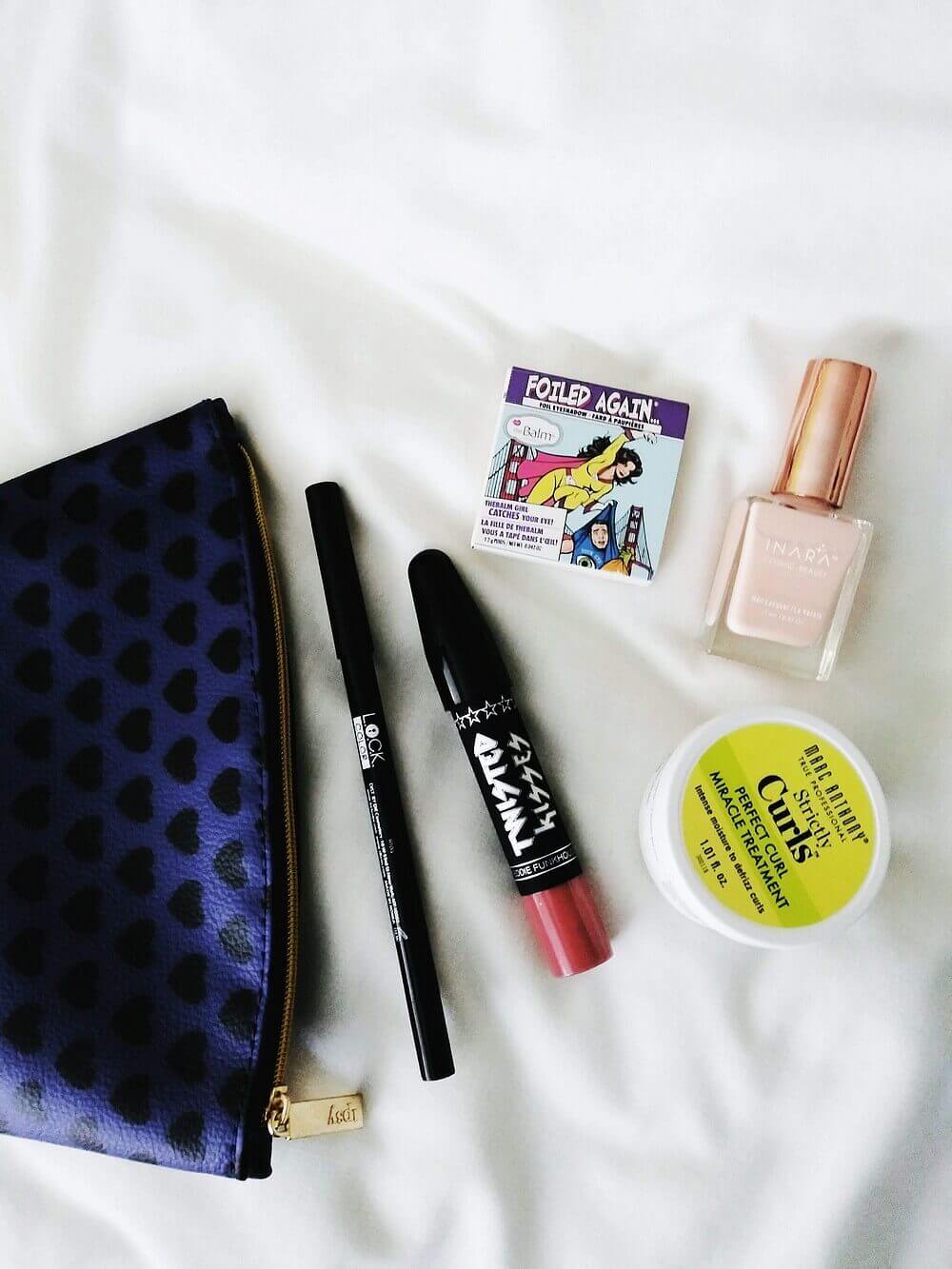 Cosmetic bag, four makeup items, one hair item