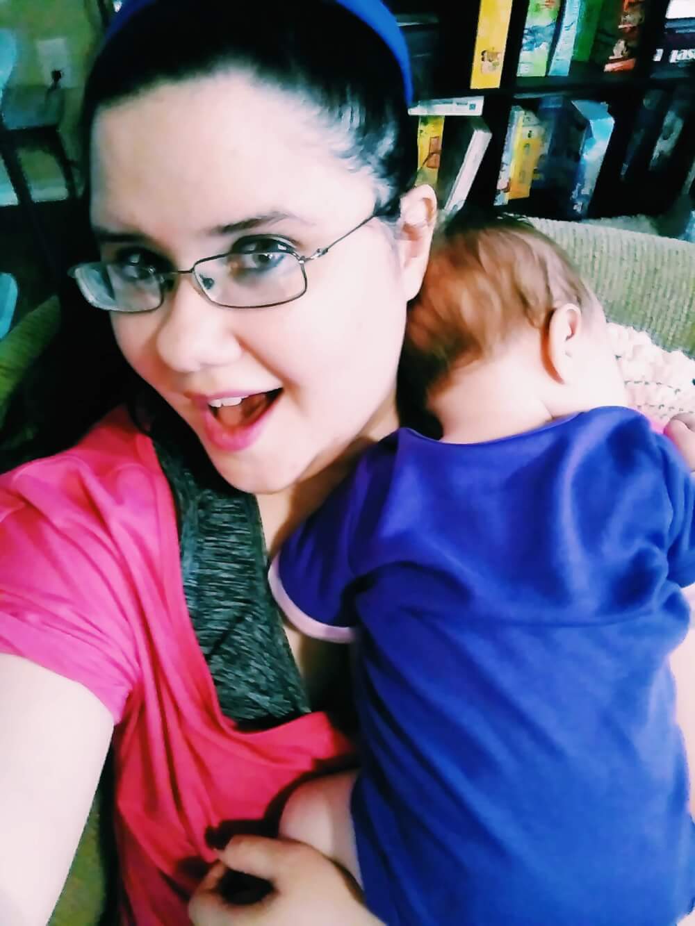 Selfie of me smiling while a baby is asleep on my shoulder