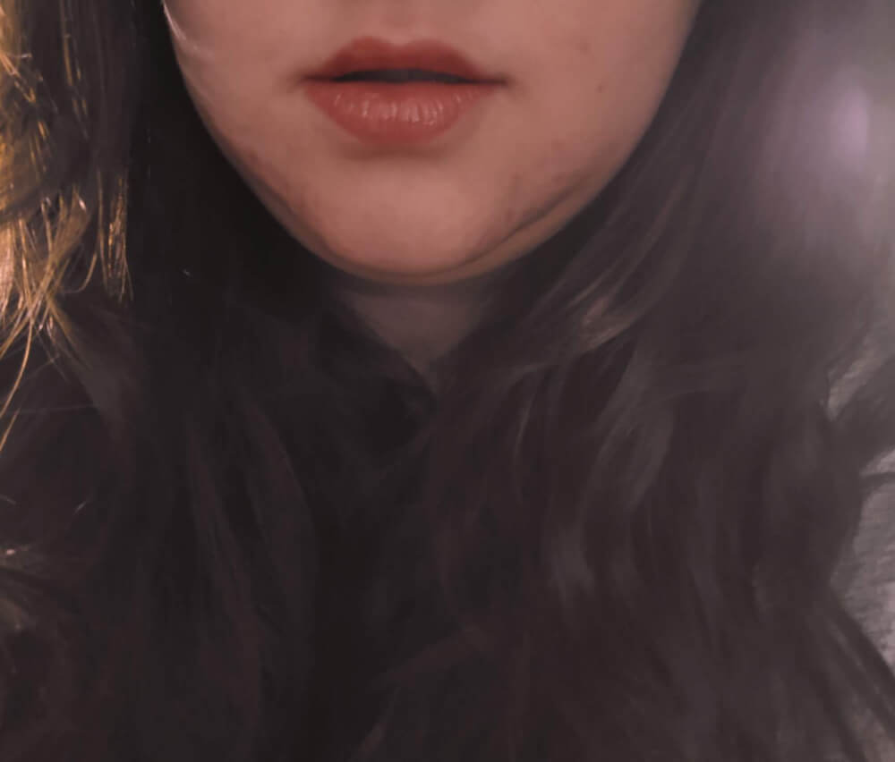 Lips, chin and hair under a soft filter; faceless